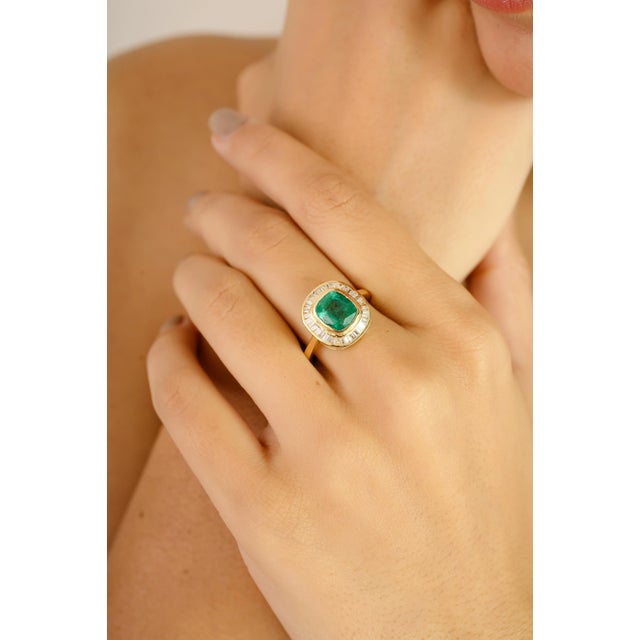 Elegantly crafted in 18k yellow gold, this stunning ring showcases a vivid 1.72-carat cushion-cut emerald at its center —...