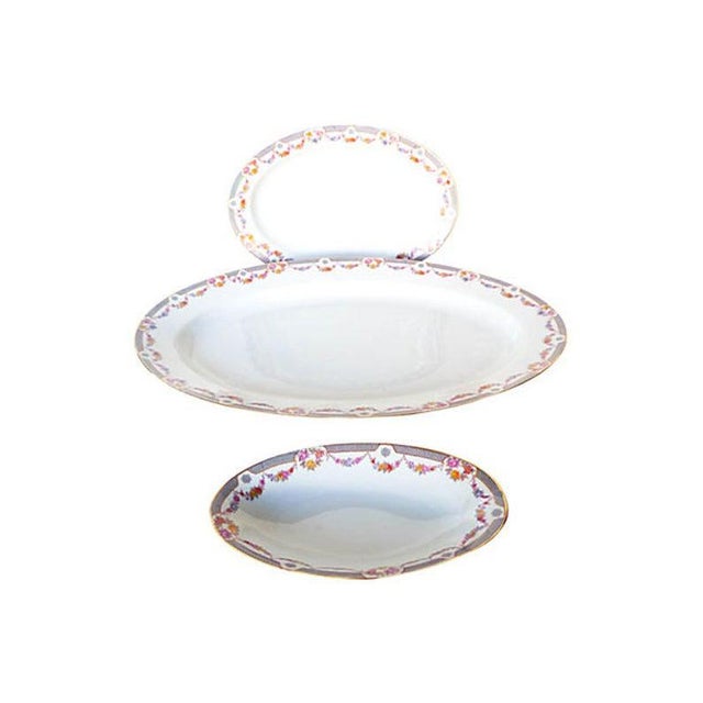 Vintage Set of three graduated porcelain platters of floral decoration with white and gray fields finished with gold trim....