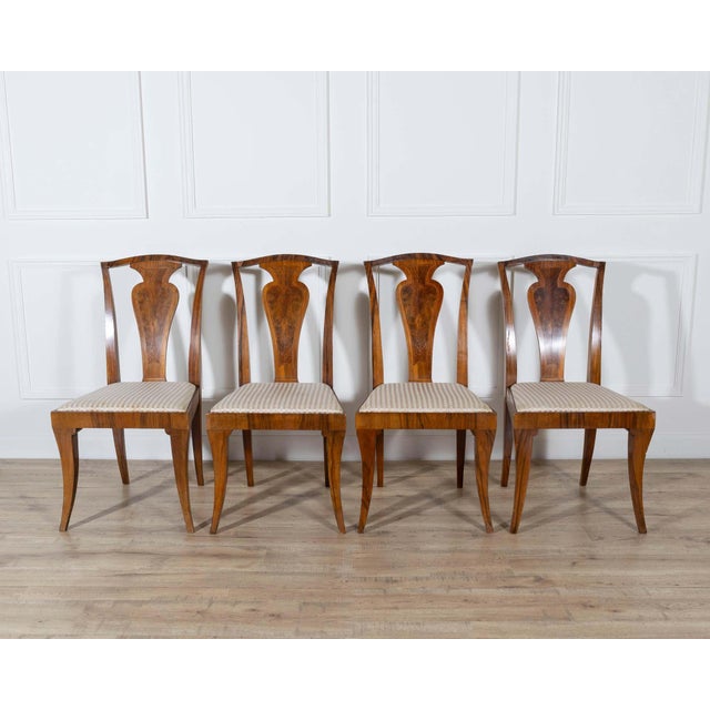 A striking set of four French Art Deco chairs from the 1920s–1930s, masterfully crafted in solid wood veneered with flamed...