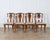 A striking set of four French Art Deco chairs from the 1920s–1930s, masterfully crafted in solid wood veneered with flamed...