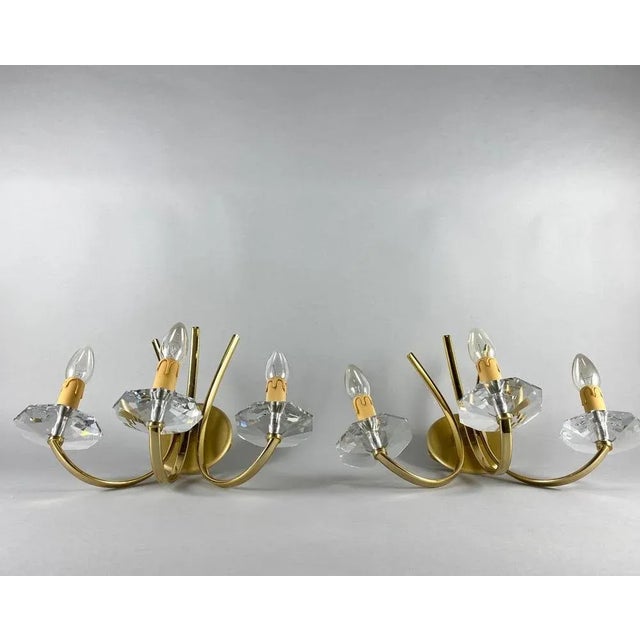 Classic designer sconces in gilt brass with three horns (candles) with crystal bobeche from the famous portuguese company...