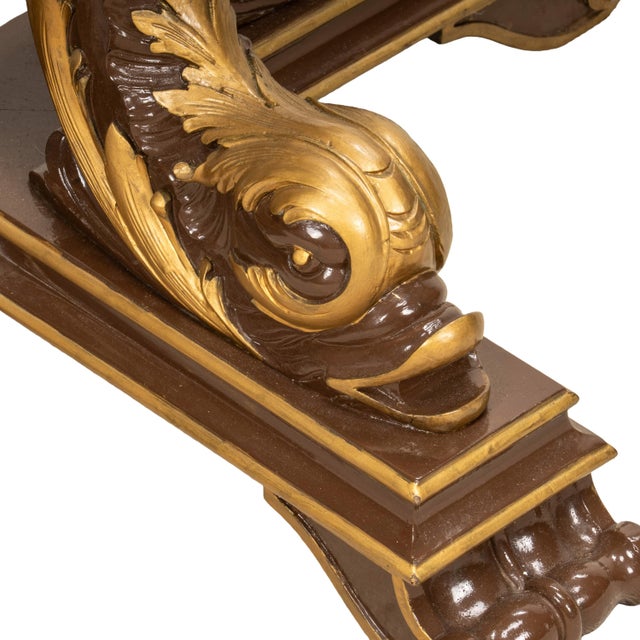 An impressive vintage coffee table featuring a dramatic neoclassical-inspired sculptural base with gilt accents supporting...