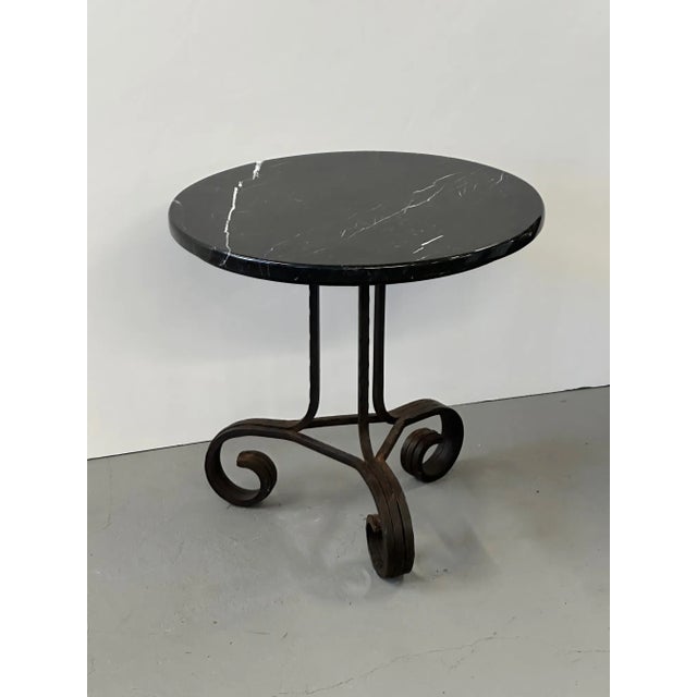 Beautiful art deco French end table having hand wrought iron base (17.5 diameter) with round black marble top.