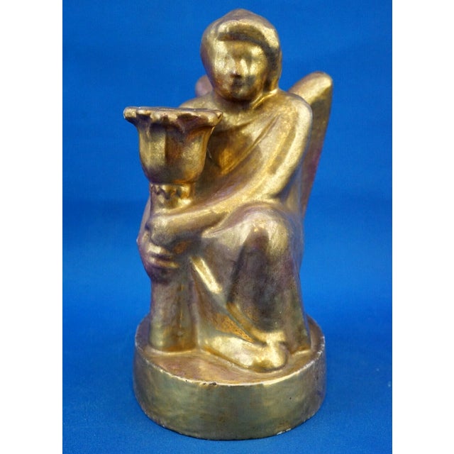 a stunning, hand-sculpted terracotta candle holder in the shape of a kneeling angel. A unique piece, it features a...