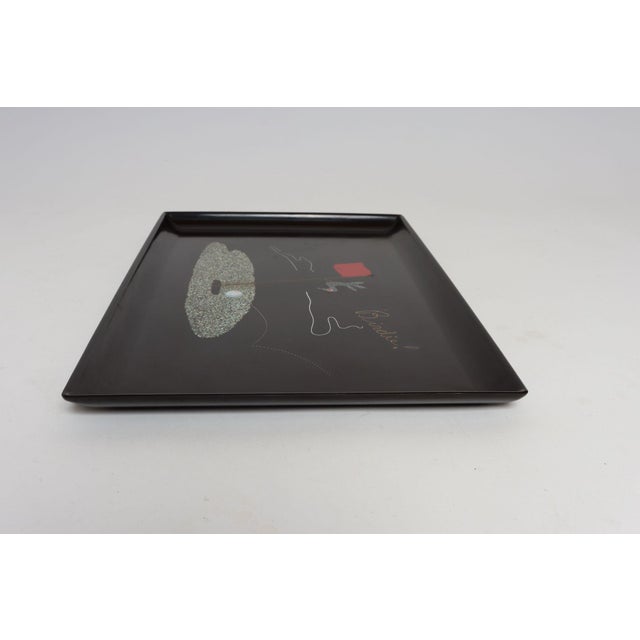 Rectangular tray by Couroc of Monterey, California depicting a bird perched on a flag on the golf green above a ball...