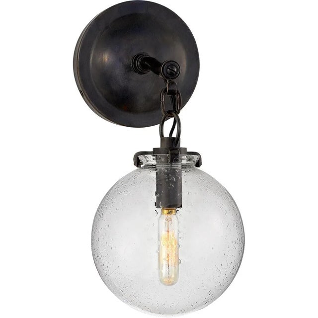Katie Small Globe Sconce in Bronze with Seeded Glass Designer: Thomas O'Brien Height: 12.5" Extension: 9.75" Backplate:...