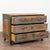 19th-century chest of three drawers crafted in pine with its original hand-painted finish. The background is a soft aged...