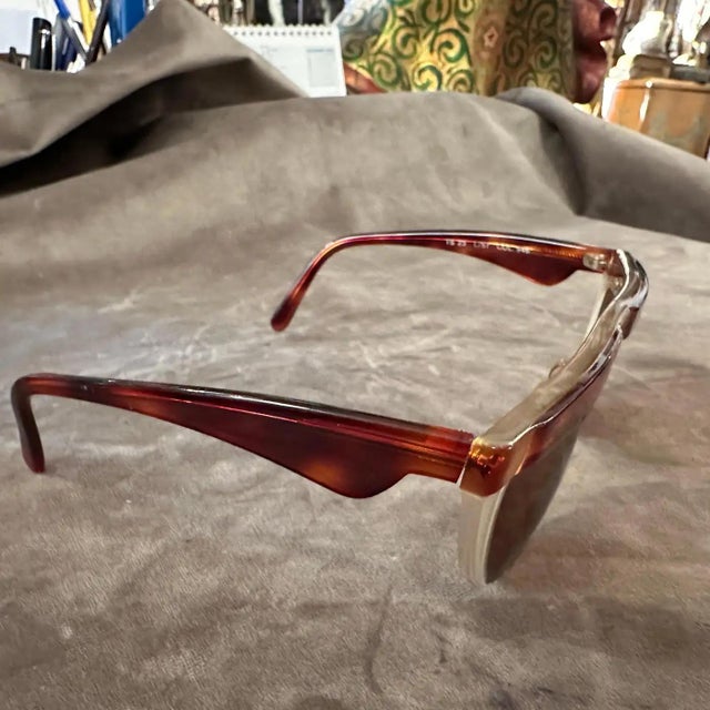 These sunglasses are a vintage piece from the 1990s, crafted by the Italian luxury brand Trussardi. They feature a...