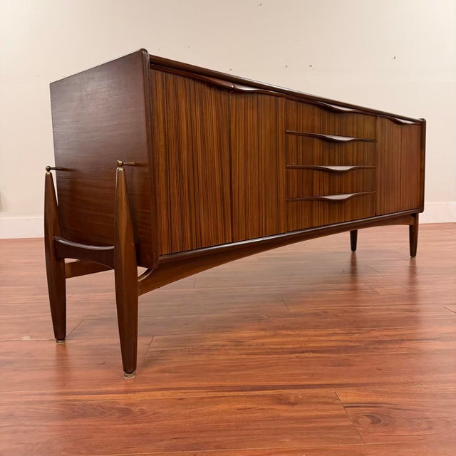 Striking vintage mid-century sideboard made in the U.K. by Elliott's of Newbury circa 1960's. Design cues include rocket-...