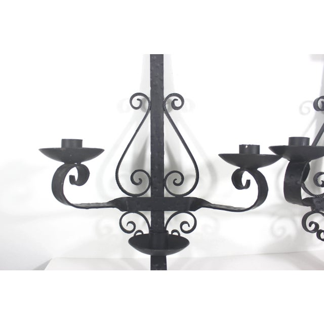 Pair of large black wrought iron three arm candle sconces made in Spain.these have beautiful hammered detail on the metal...