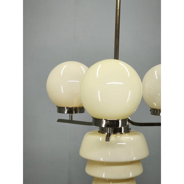 Striking Art Deco chandelier produced in Czechoslovakia during the 1930s, combining cream opaline glass with a sculptural...