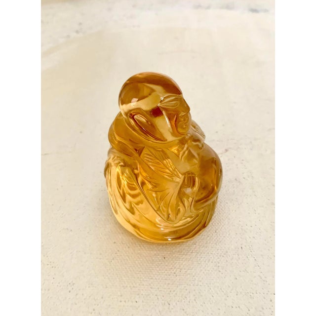 Small Buddha figure made of amber colored crystal. Very similar to Baccarat or Lalique figures, but unsigned, so maker is...