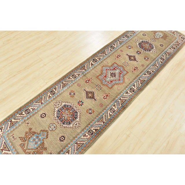 This traditional tribal geometric Caucasian Kazak runner is hand-knotted with an all-wool pile on a cotton foundation....