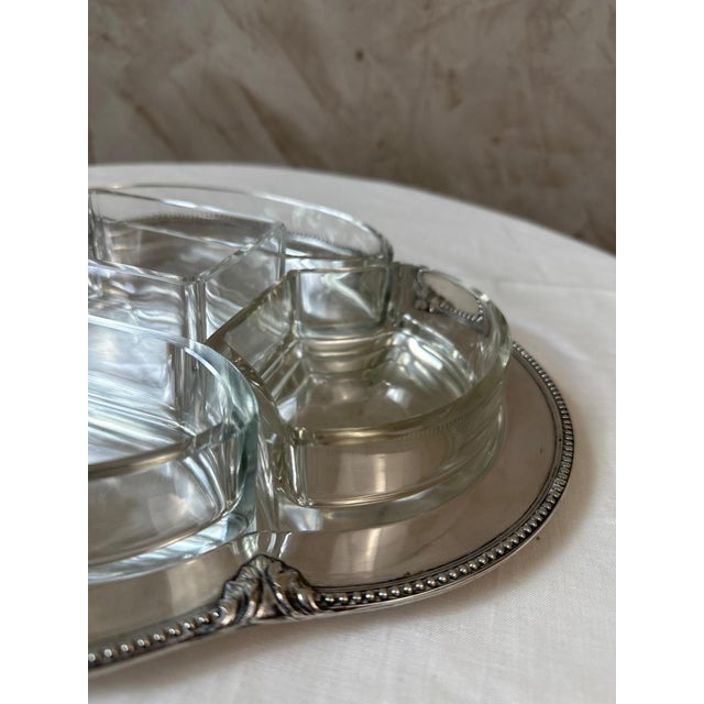 An elegant early 20th-century serving tray, crafted from silver-plated metal and accompanied by its five original glass...