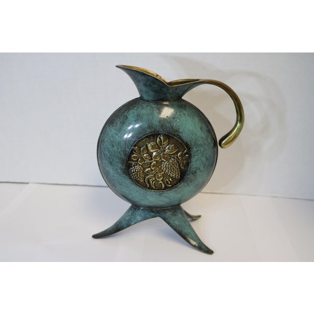 Beautiful bronze pitcher with 3 feet and grape motif medallion in the center. Very unique shape. I love the green enamel...