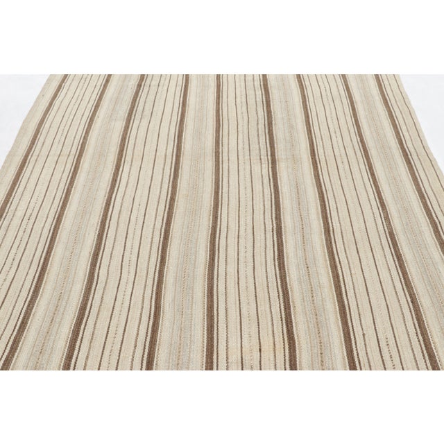 Made with handwoven wool circa 1950-1960, this 7x8 vintage Kilim is a particularly bright and sought-after work of an...