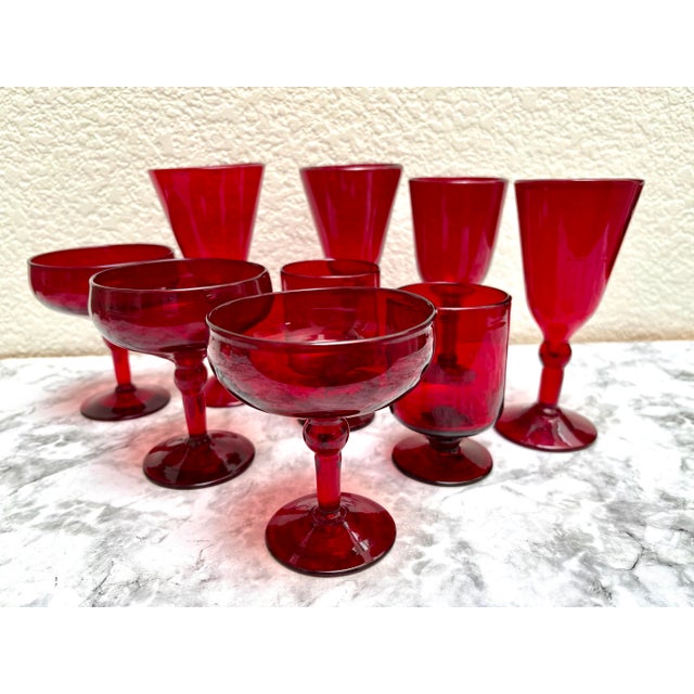 Vintage set of nine ruby red assortment of cocktail glasses including champagne coupes, wine or water goblets, and flutes....