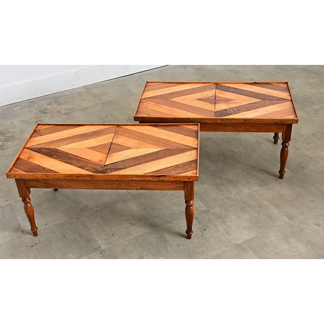 A very unique pair of vintage mid-century French coffee tables inlaid with parquet flooring on the top surface mixing...