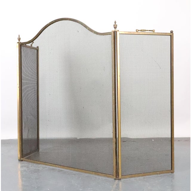 Traditional style fireplace screen made of black mesh steel panels with a brass frame and two handles. Good condition with...