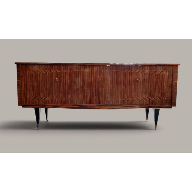 A French dining room ensemble of exceptional elegance: a sideboard, dining table, and six chairs combine expressive veneer...