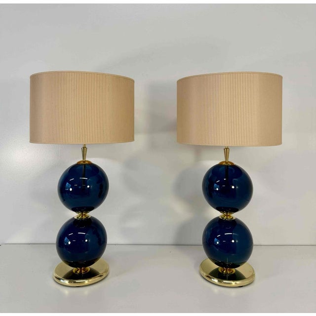 This elegant pair of lamps was handcrafted in Murano, Italy, in the 2000s. Each lamp features two hand-blown Murano glass...