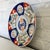 A 19th century Japanese Imari porcelain charger with a hand-painted botanical design in traditional Imari colors. This...