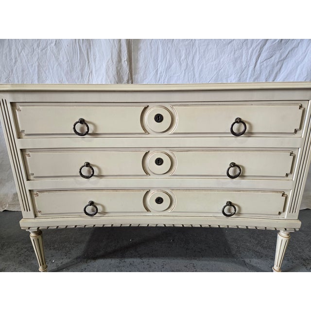 This elegant French Neoclassical commode dates to the mid-20th century (circa 1940–1960) and reflects the enduring...
