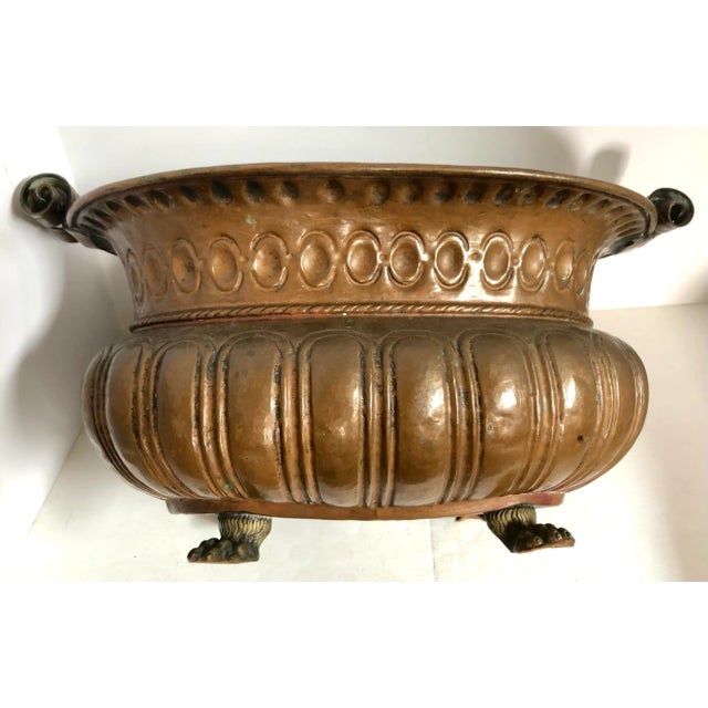 Hand hammered and tooled copper jardiniere with liner and brass lion feet. No holes seen in liner or jardiniere.