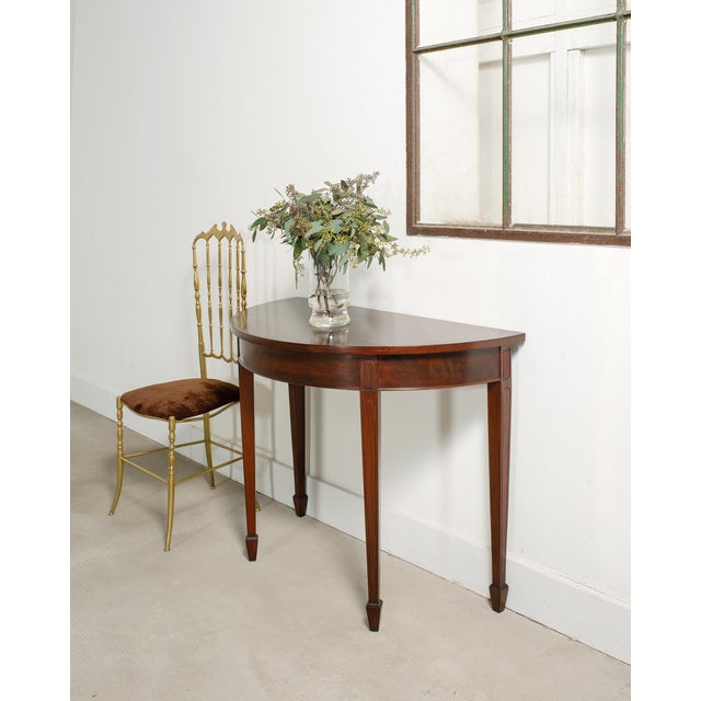 Gorgeous pair of mahogany demi-lune console tables or center table crafted in the Georgian taste. The tables have joining...