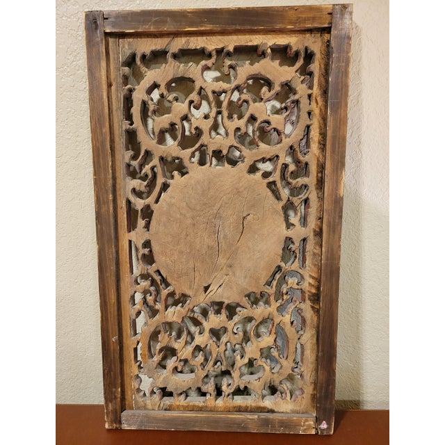An impressive antique Chinese carved wood panel, depicting relief gilded figurines and motifs.