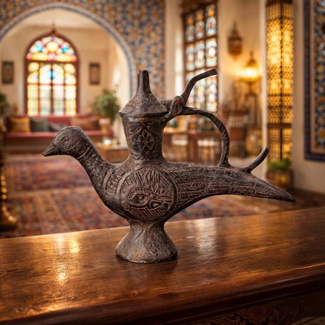 A rare 17th‑century Turkish brass oil lamp crafted in the form of a stylized bird, bearing an Islamic‑calendar date...