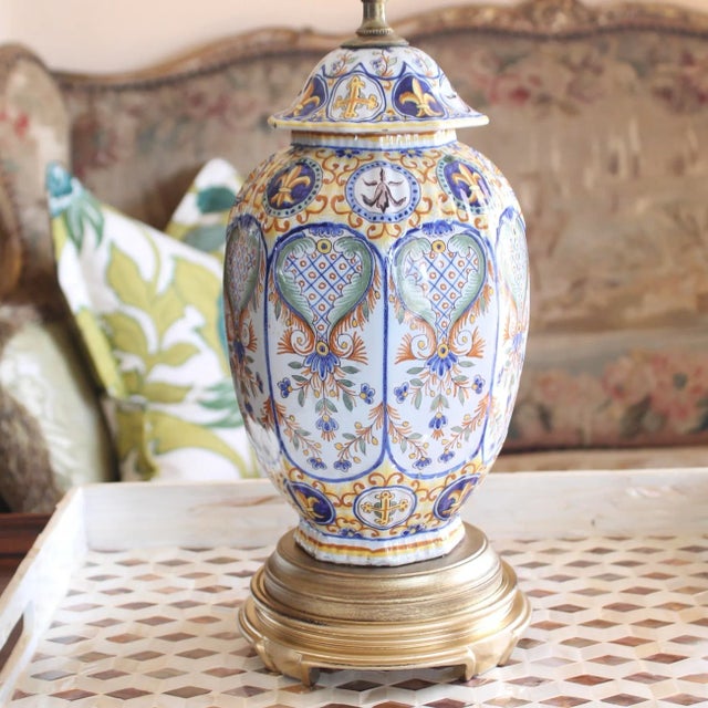 A fine and rare French polychrome Faience (glazed earthenware) covered jar made into a lamp and mounted on a gilded base....