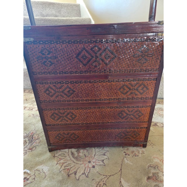 Beautifully woven with dark and light colored rattan small portable chest with split bamboo handle and carved wood side...