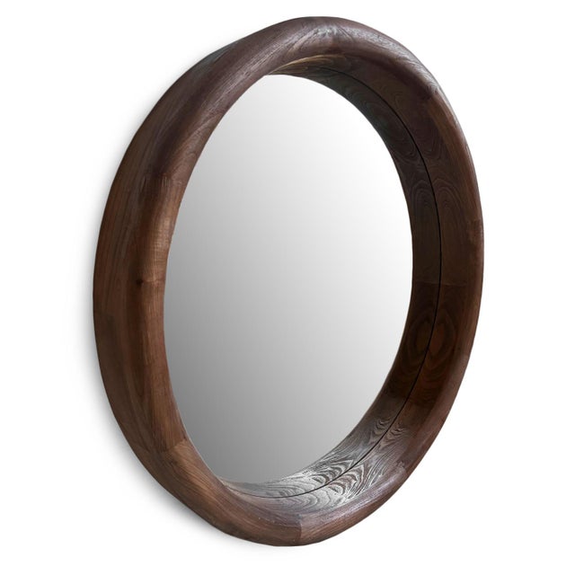 Impressive oversized round wall mirror framed in solid Mindi wood with a beautifully thick, hand-finished profile that...