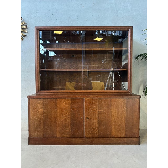 Original display cabinet. Oak. Art Deco period. Rounded doors. Remarkable brass key and ball hinges. 2 sliding glass...