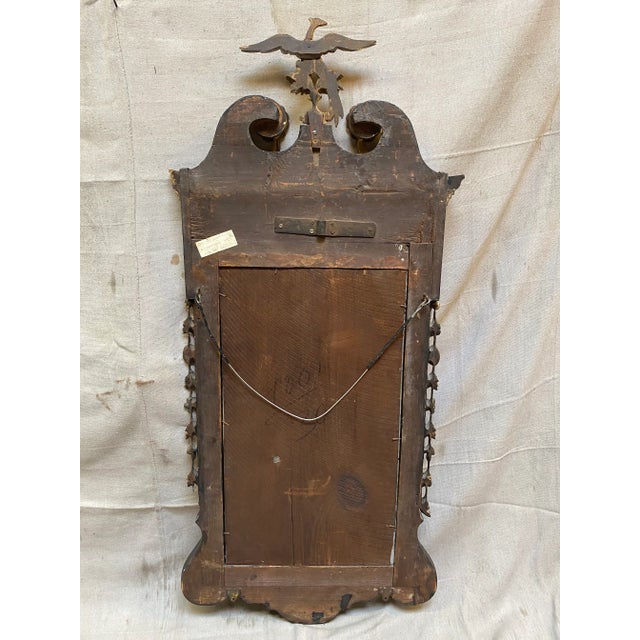True antique Federal style gilded wall mirror, circa 19th century. A carved Phoenix crest surmounts the mahogany frame....