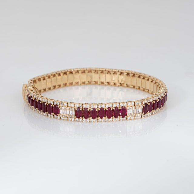 Stylish contemporary ruby & diamond bracelet crafted in 14 karat yellow gold. Oval faceted rubies total an estimated 5.93...