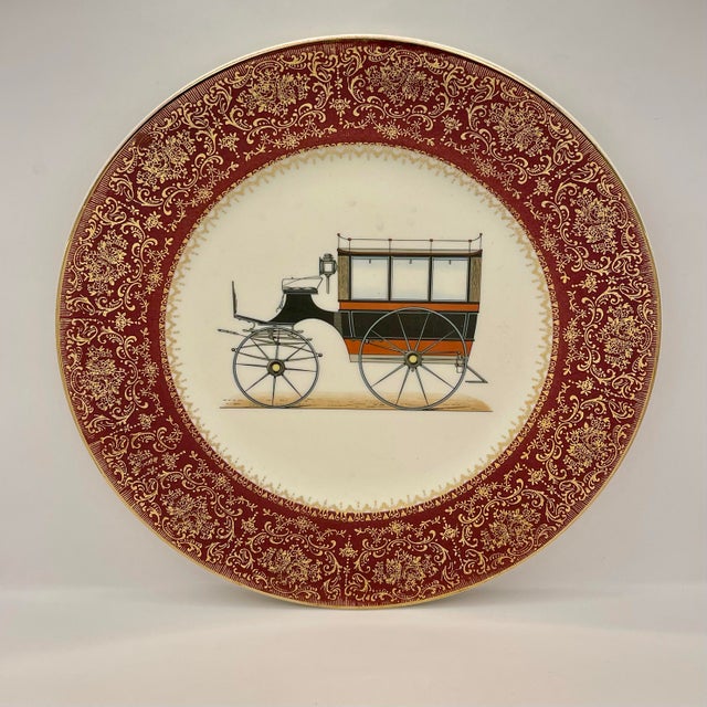 A Salem China 23k gold trimmed plate decorated with an 19th century carriage circled by an elaborate scrollwork border.