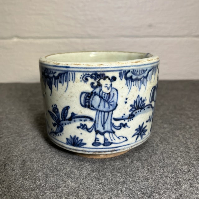 White & blue glaze porcelain with hand painted scene of people working in harmony.