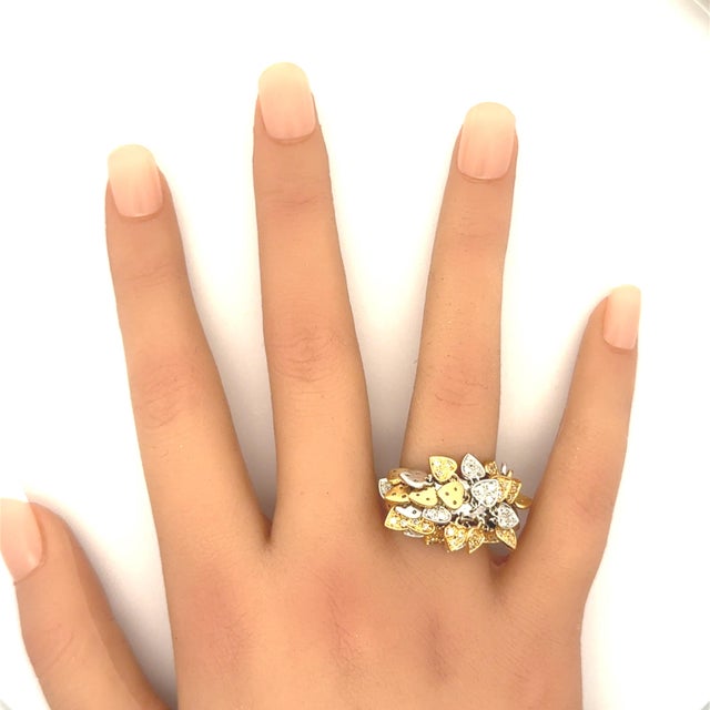 A captivating ring adorned with heart-shaped charms in yellow and white gold. Each charm is encrusted with round-cut...