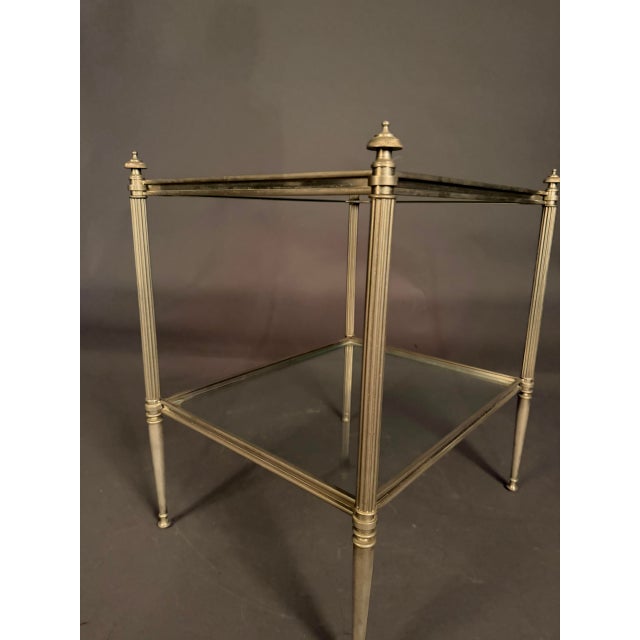 Elegant French mid-20th-century small side table, circa 1950, featuring a refined nickel-plated bronze frame and two tiers...