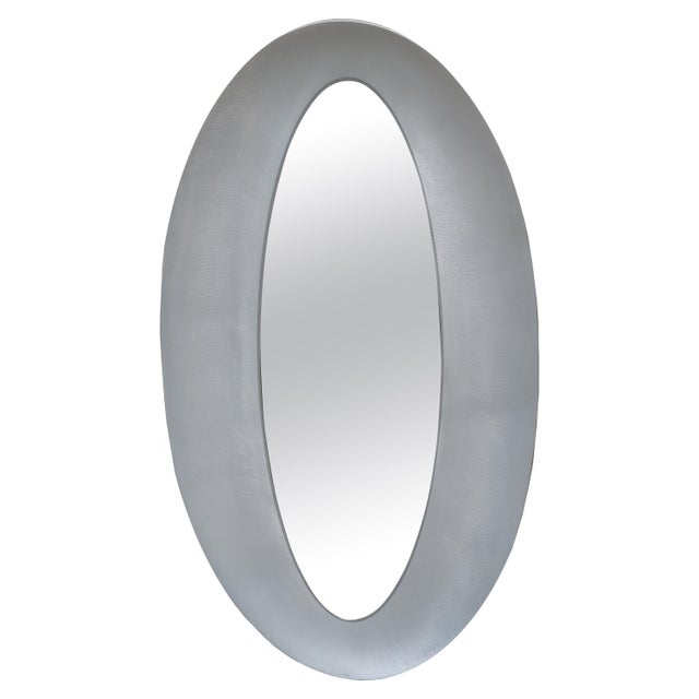 A sculptural modernist oval mirror by artist Lorenzo Burchiellaro. Textured cast aluminum with a slightly concave shape....