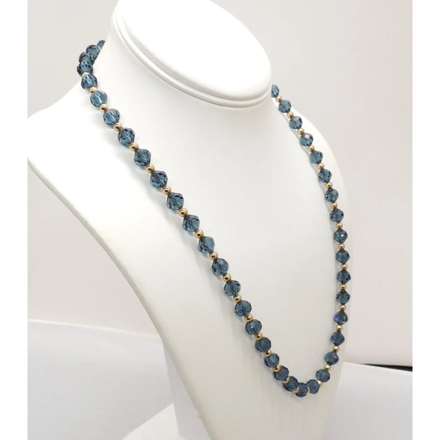 This is part of Chairish’s Costume Jewelry assortment. 1960s goldtone and faceted blue glass beads with goldtone spacer...