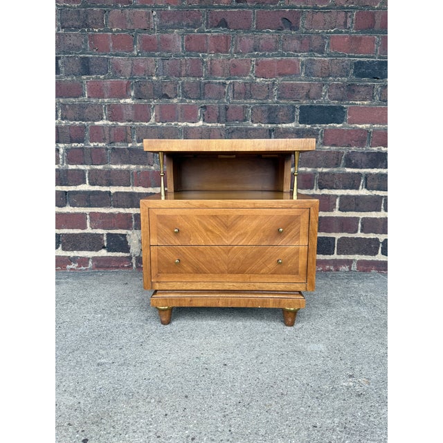 A rare and beautifully detailed nightstand by American of Martinsville, featuring brass knobs, unique mixed-wood inlay,...