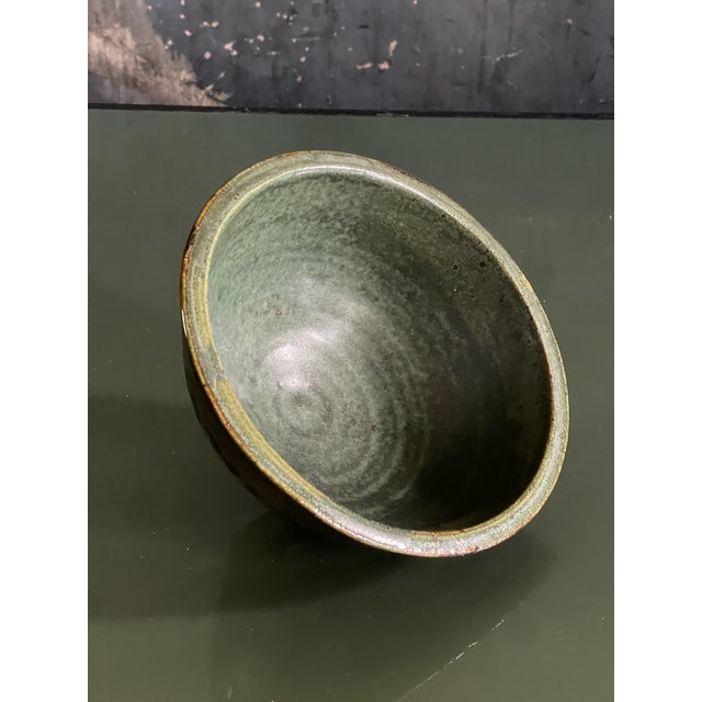 Very nice understated studio pottery bowl featuring a deep glaze exterior and a neutral green glazed interior. Exterior...