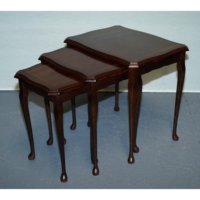 Antiques of London Elegant vintage set of three mahogany nesting tables crafted in the refined Queen Anne style. Featuring...