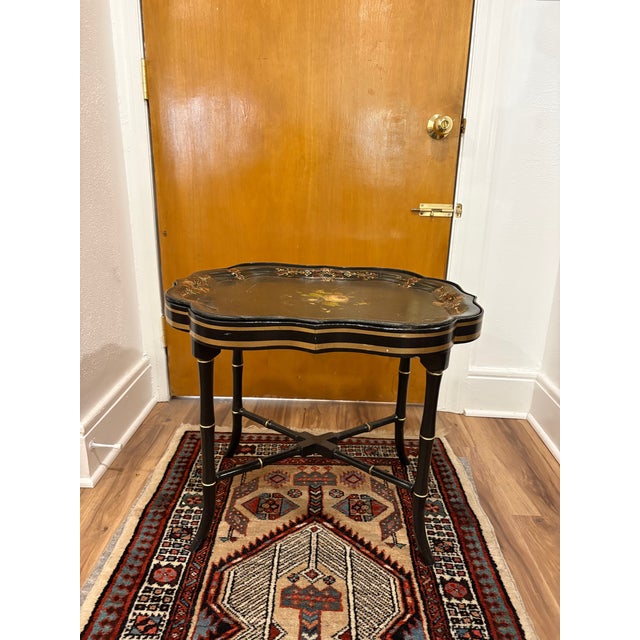Nice little traditional tole hand-painted black tray table. Tray is wood, not metal. Comes out like any other tray table....