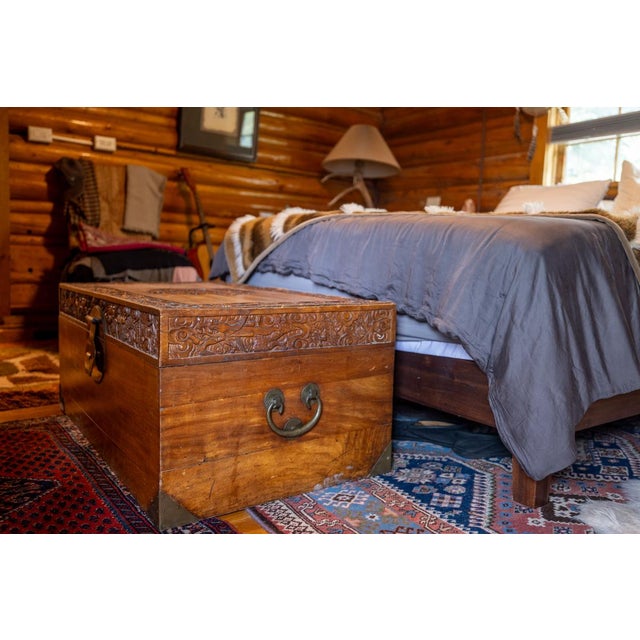 This antique Chinese camphor wood blanket chest is a beautifully hand-crafted example of traditional Chinese decorative...