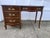 A distinctive asymmetrical design featuring a three-drawer pedestal on the left and a single long lap drawer beneath the...