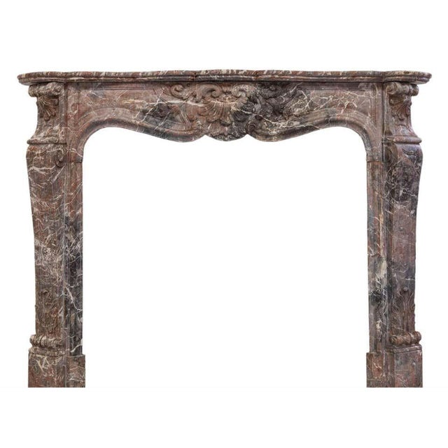 19th century louis xv style beautiful fireplace sculpted in a soft colored rouge royal marble. The finely carved shelf...
